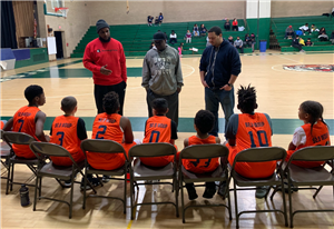 Basketball coach talking to teens.
